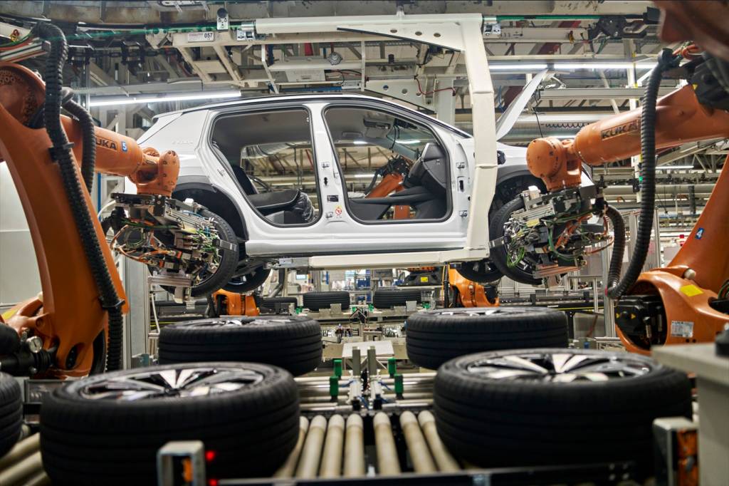 Colaboradora da fábrica a inspecionar a traseira branca do novo SUV elétrico Škoda Epiq na linha de montagem.